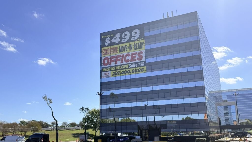 Perforated window vinyl reading $499 executive offices across the upper floors of a Houston office building