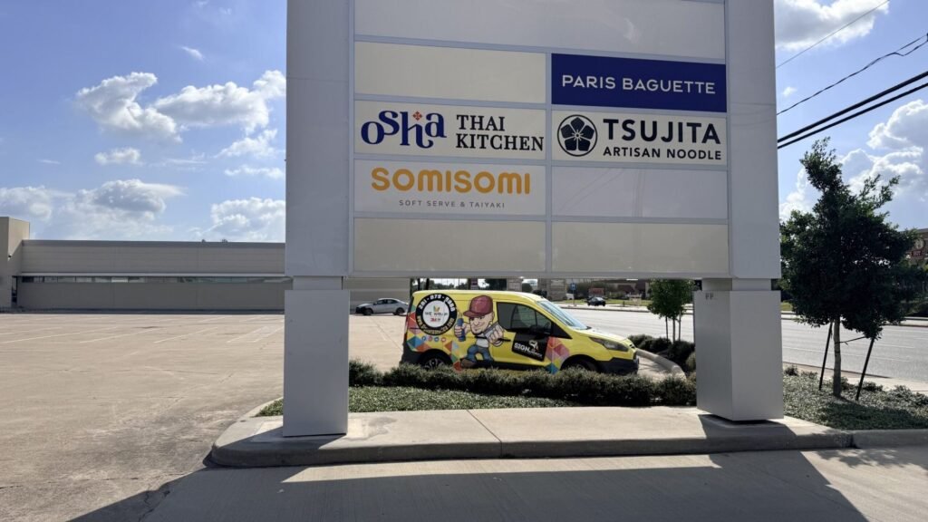 Printed tenant panels on a Houston shopping plaza sign